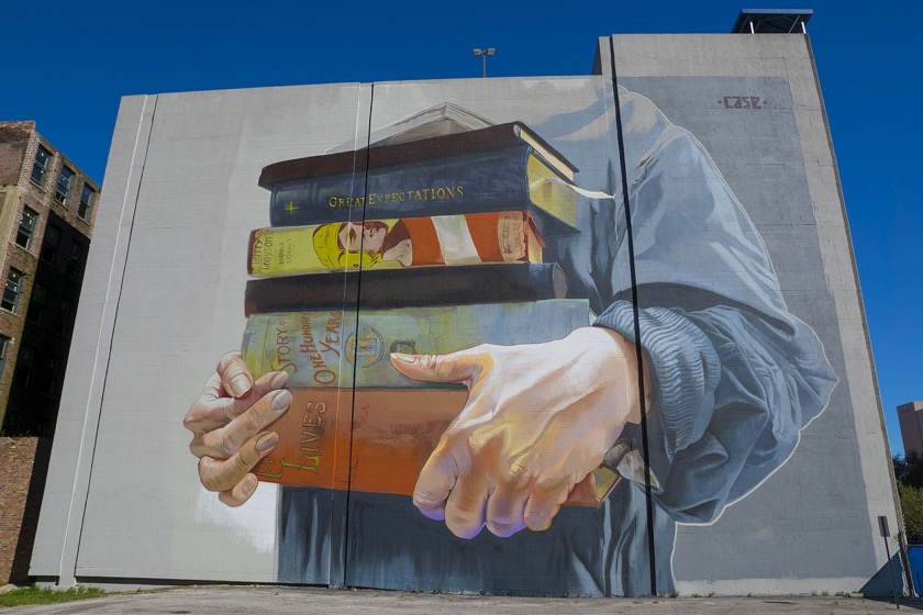 A stack of books mural by Case Maclaim in Jacksonville, Florida